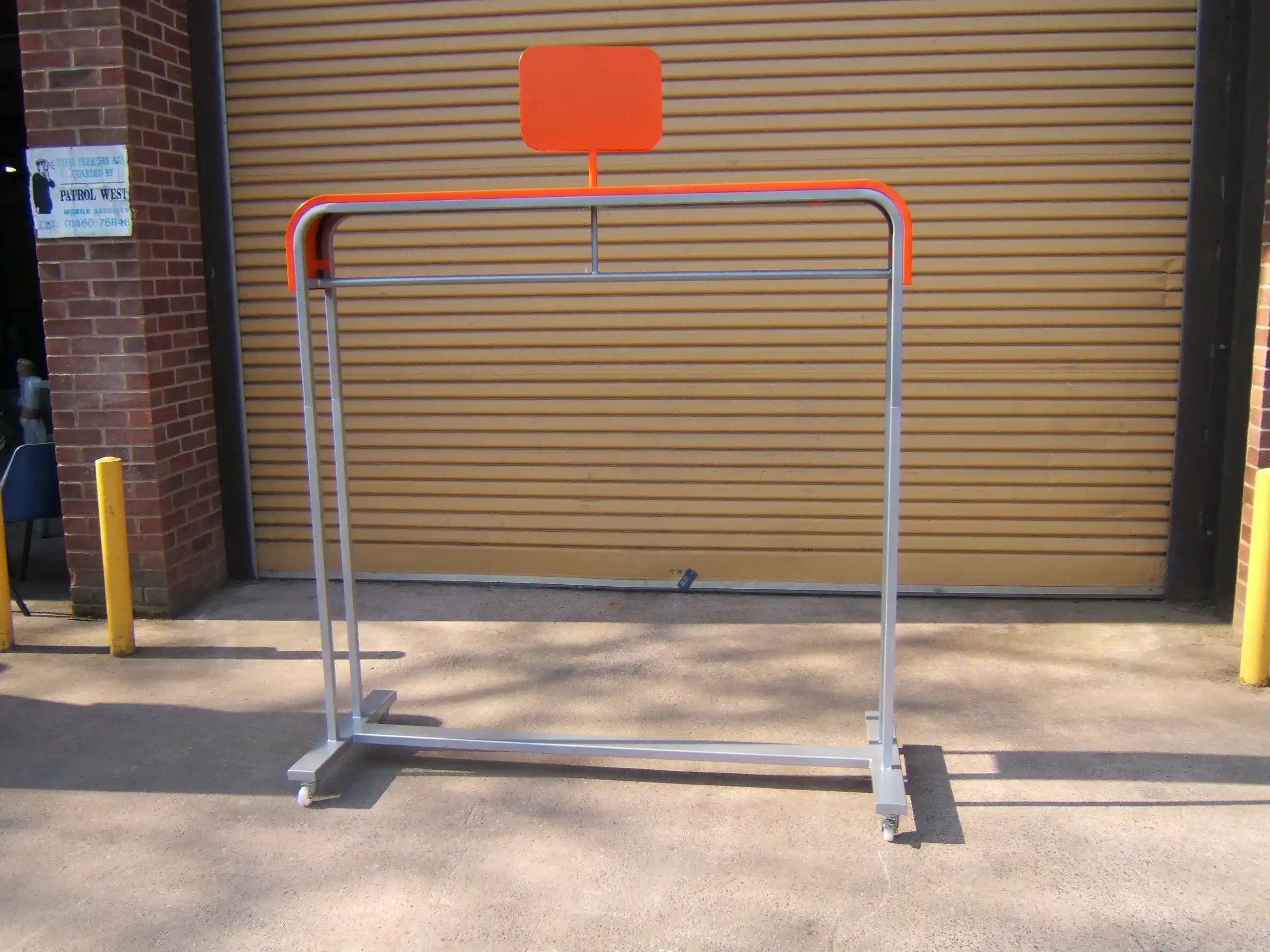 Freestanding Retail Garment Display Rail manufactured by Techrail Mobile powder-coated clothing rail with a high-level promotional header panel.